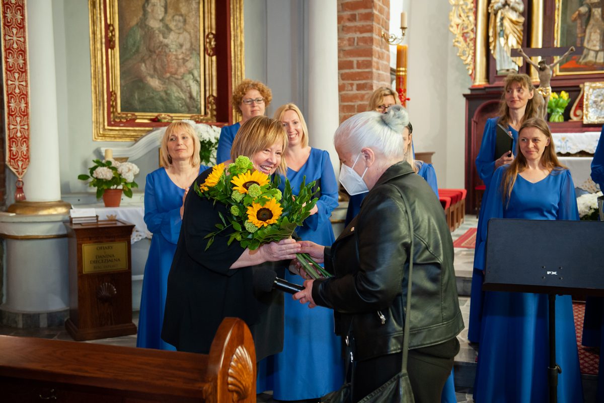 Dyrygent Elżbieta Wtorkowska, dyrektor ośrodka kultury Arleta Włodarczak i grupa chórzystek Żeńskiego Chóru „Canzona-Absolwent”