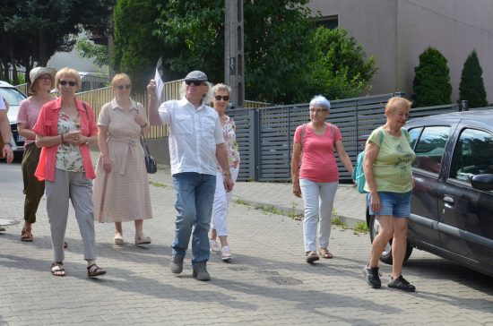 Grupa osób schodzi z górki po ulicy