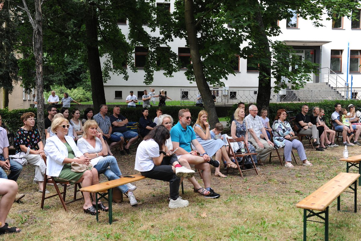 Publiczność na ławkach i krzesłach