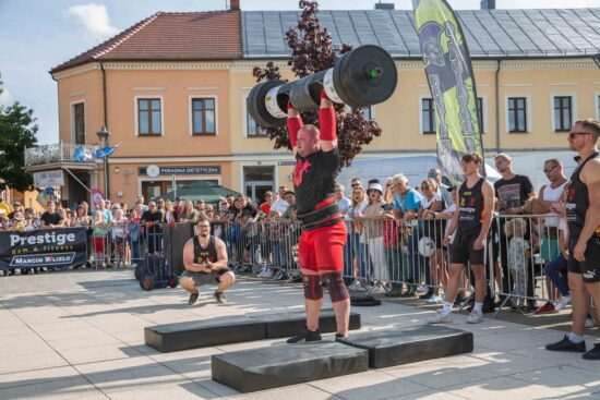 Strongman podnosi ciężar.