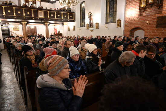 Oklaski publiczności w nawie kościoła.