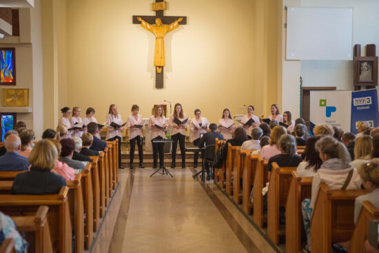 Chór Kameralny Vivace z Pamiątkowa, w ławach kościelnych publiczność.