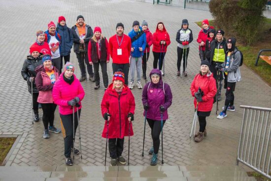 Grupa ludzi z kijkami do nordic walking na placu