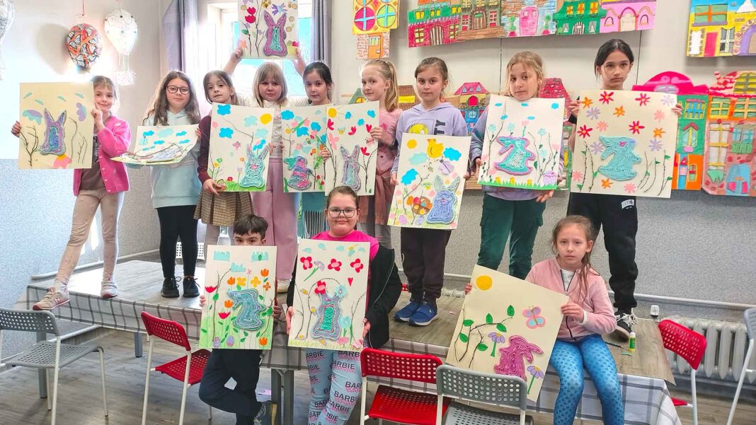 12-f Grupa dzieci pozująca ze swoimi obrazami