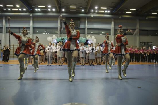 Grające orkiestry dęte oraz tańczące mażoretki na hali widowiskowo-sportowej.