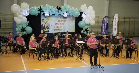 Muzycy orkiestry dętej wraz z kapelmistrzem
