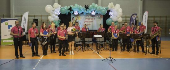 Muzycy orkiestry dętej wraz z kapelmistrzem