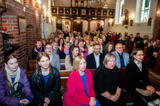 publiczność w kościelnych ławkach