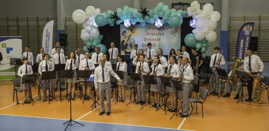 Muzycy orkiestry dętej wraz z kapelmistrzem