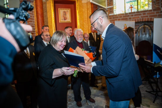 mężczyzna wręcza kwiaty kobiecie