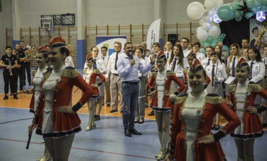 Dyrektor wśród muzyków oraz mażoretek wita publiczność