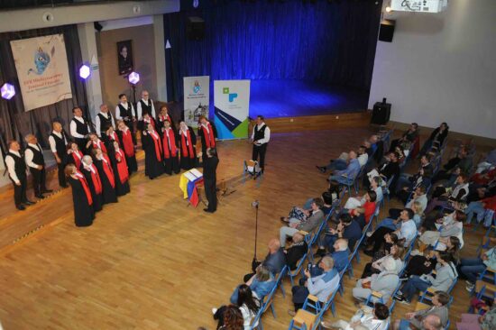 Chór z dyrygentem na scenie, publiczność