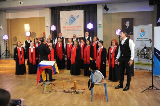 Chór z dyrygentem na scenie, na pierwszym planie solista