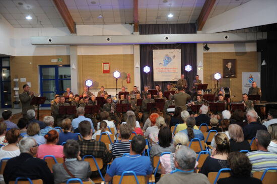 Orkiestra Wojskowa z Bydgoszczy gra na scenie oraz publiczność