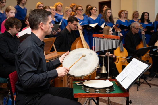 Muzyk grający na instrumentach perkusyjnych w tle chór