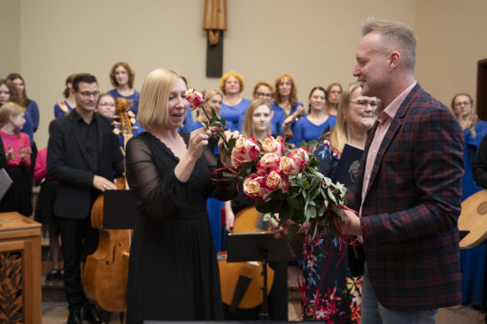 Organizatorzy wręczają kwiaty i statuetkę dyrygentce