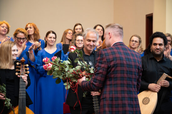 Organizatorzy wręczają kwiaty i statuetkę muzykowi