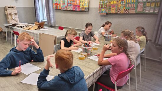 dzieci malujące przy stołach