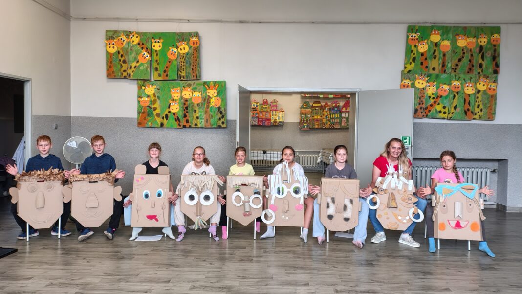 4 dzieci pozujące do zdjęcia z maskami z kartonu grupa 2