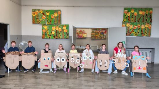 dzieci pozujące do zdjęcia z maskami z kartonu grupa 2