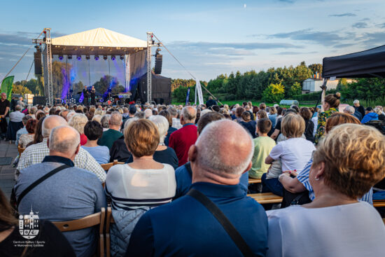 ludzie siedzący przed sceną