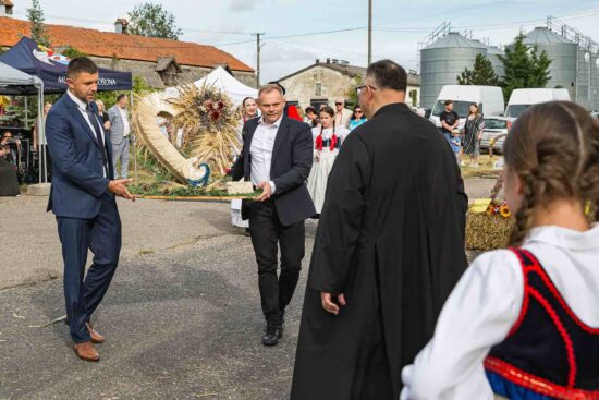 Delegacja wręcza wieniec dożynkowy gospodarzom dożynek.