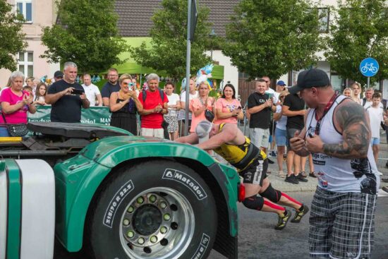 Strongman przesuwa tira.
