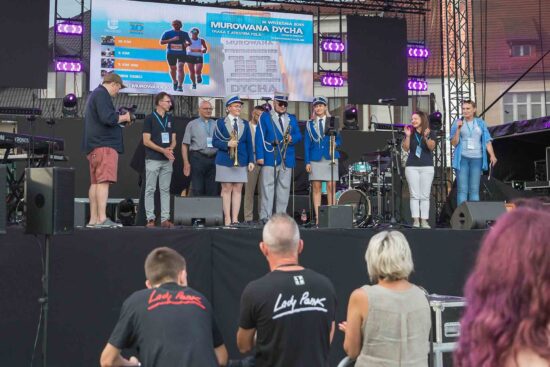 Grupa osób na scenie podczas oficjalnego otwarcia jarmarku.
