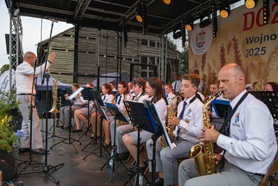 Orkiestra dęta gra na scenie.