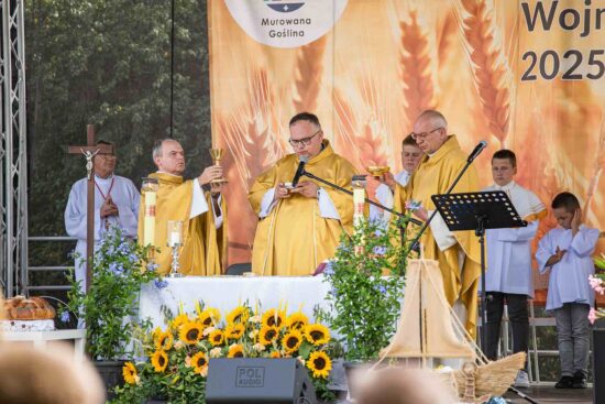 Księża przy ołtarzu na scenie podczas mszy polowej.