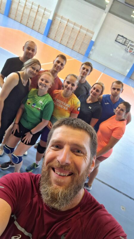 grupa ćwiczących z prowadza cym zajęcia z siatkówki