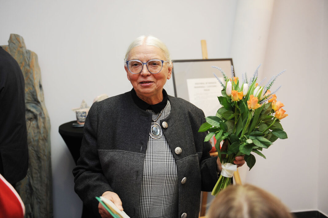 Autorka wystawy z bukietem kwiatów