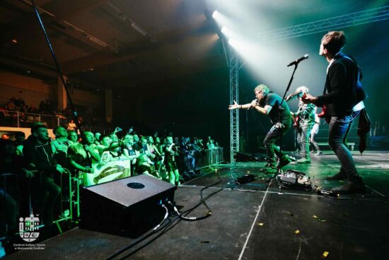 Zespół gra na scenie, publiczność pod sceną