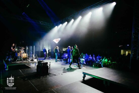 Zespół gra na scenie, publiczność pod sceną