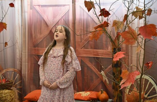 Dziewczynka, recytuje wiersz tle jesiennej scenografii 
