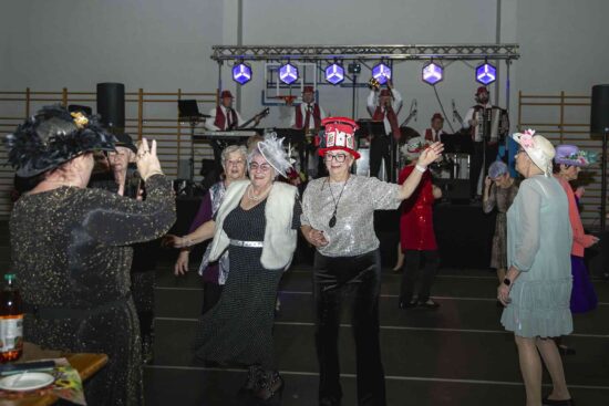 Bawiący się uczestnicy balu, w tle scena