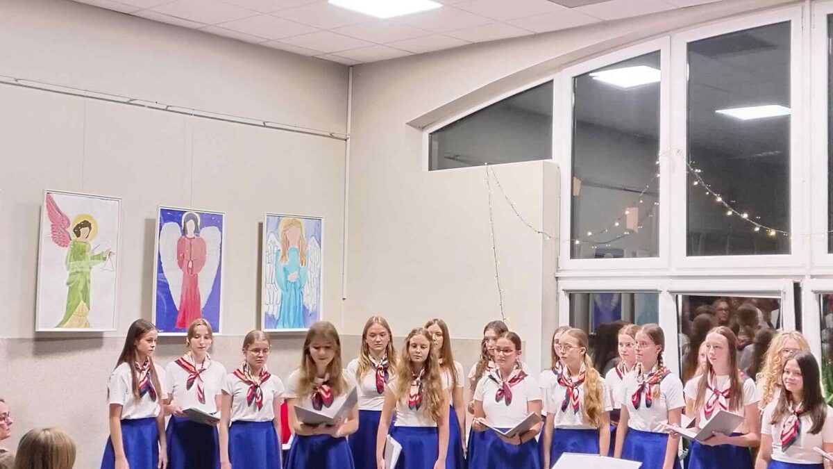 Dziewczęta w strojach stoją przed publicznością