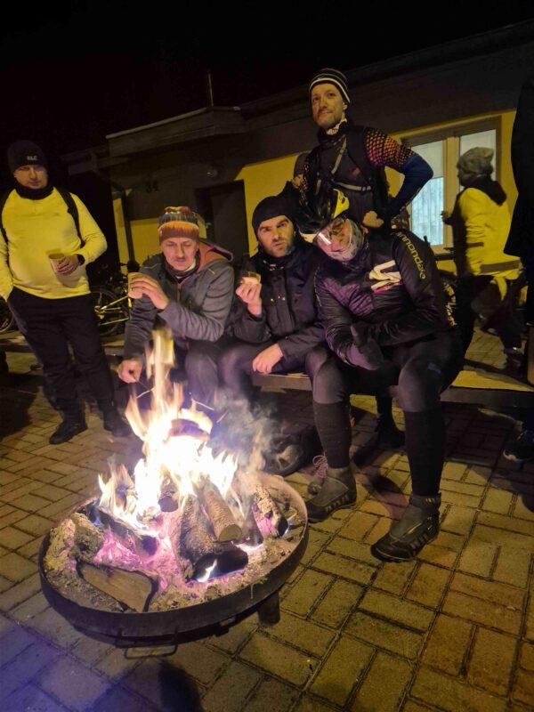 Uczestnicy z prowadzacym rajd przy ognisku na mecie rajdu