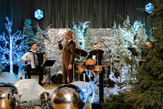 mężczyzna śpiewa na scenie ze świąteczną scenerią