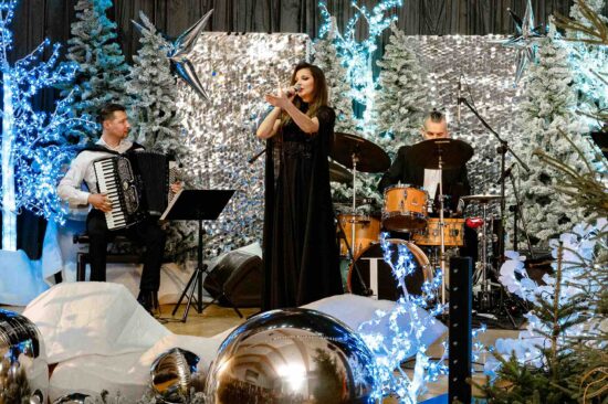 kobieta śpiewa na scenie ze świąteczną scenerią