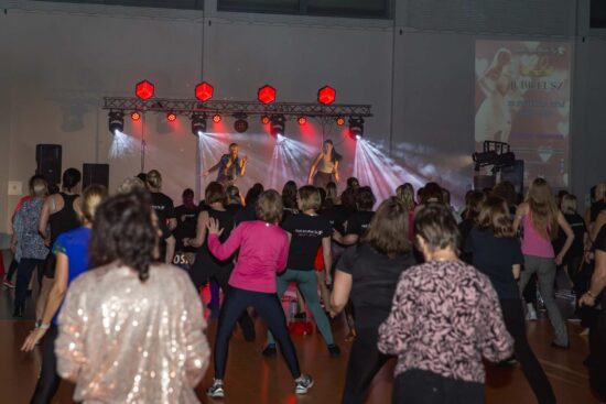 Grupa tańczących ludzi w tle scena z dwoma tancerkami