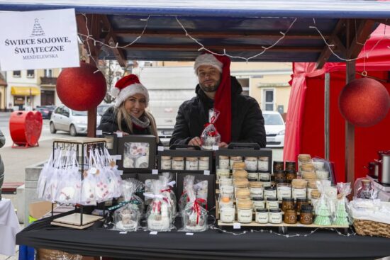 kobieta i mężczyzna przy stoisku ze świecami sojowymi