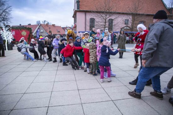 dzieci przeciągają linę na placu