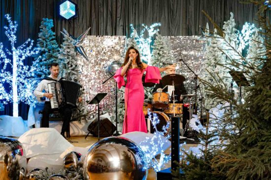 kobieta śpiewa na scenie ze świąteczną scenerią
