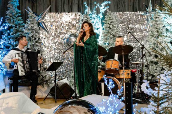 kobieta śpiewa na scenie ze świąteczną scenerią