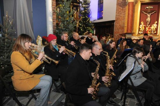 muzycy orkiestry dętej grają w kościele - zbliżenie na muzyków grających na trąbkach i saksofonach