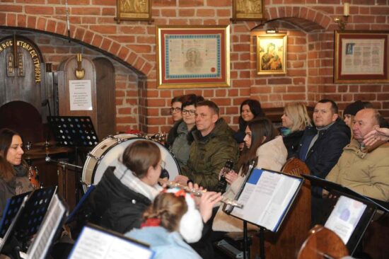 publiczność siedzi w ławkach w kościele