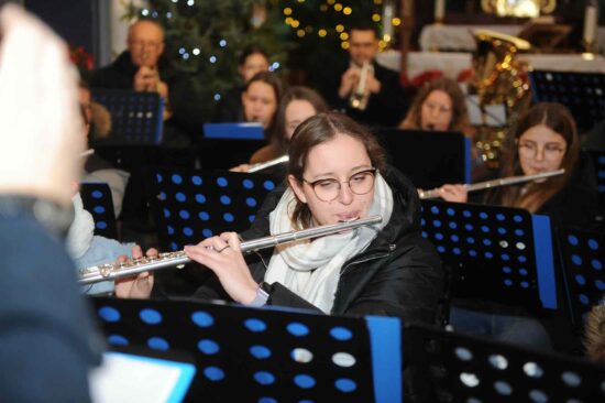 muzycy orkiestry dętej grają w kościele - zbliżenie na flecistkę