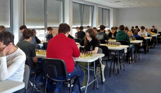 Szachiści przy stołach, szachownice, zegary