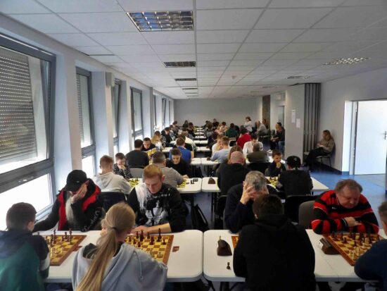 Szachiści przy stołach, szachownice, zegary